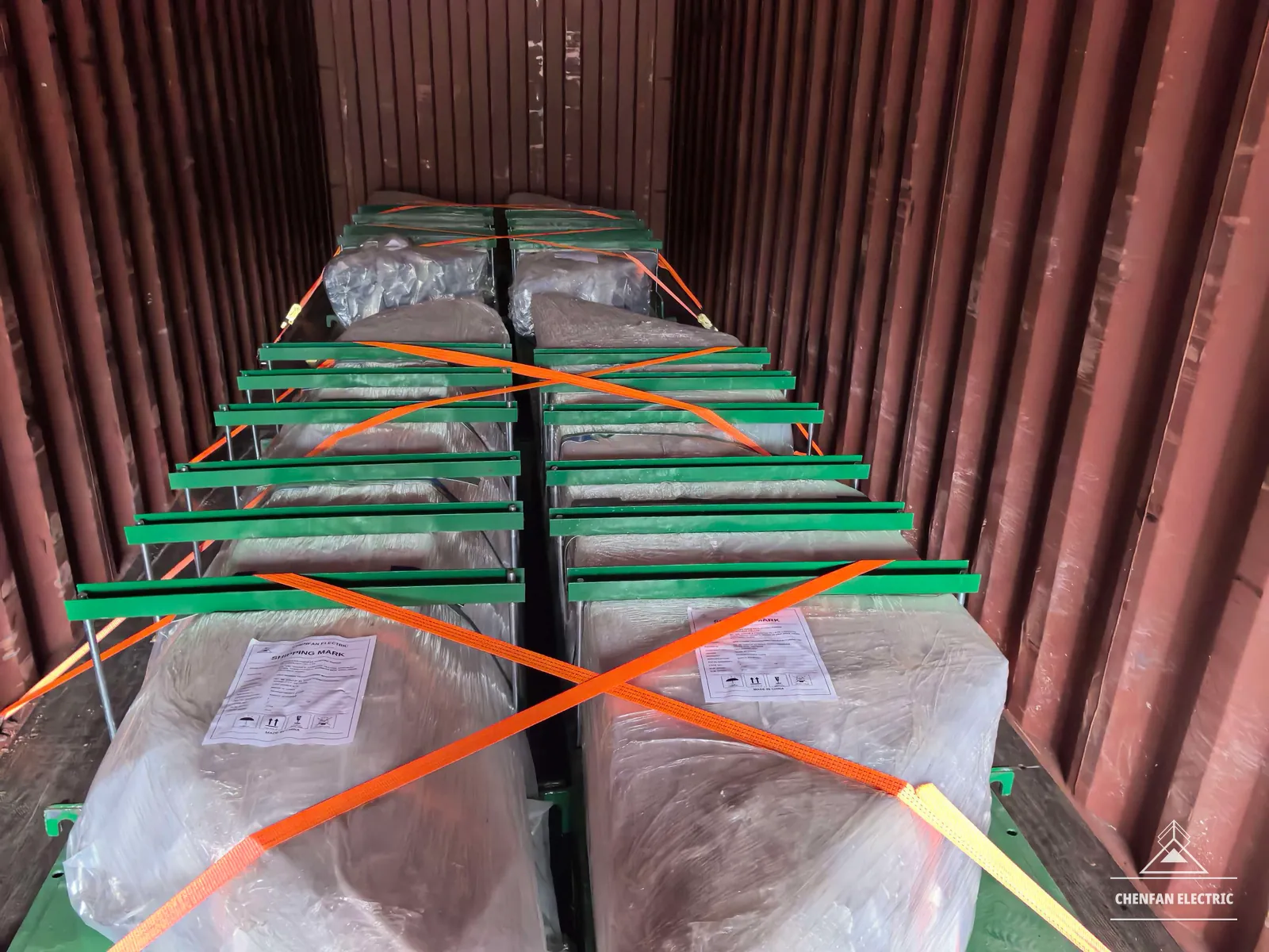 Packed transformer-core components secured inside a shipping container with crossed lashings