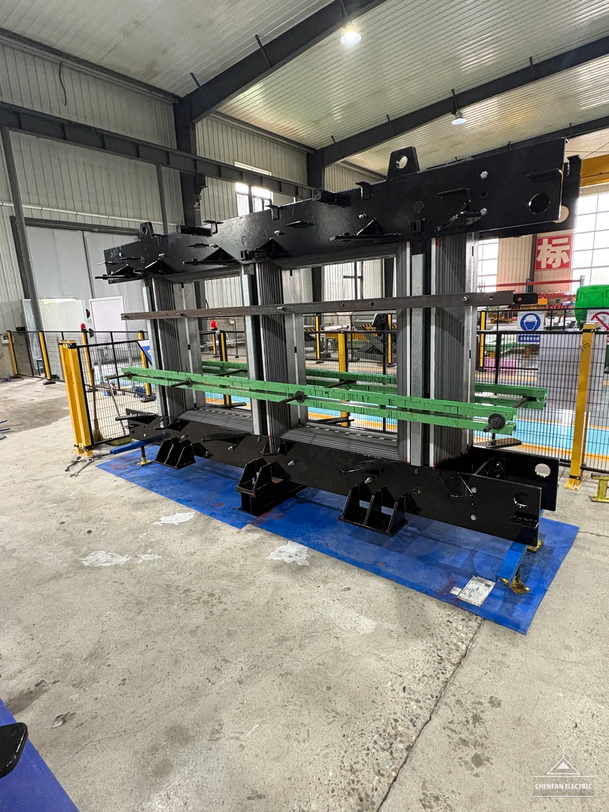 Dry-type transformer core with black clamping frames in the workshop